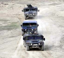 3 trucks driving in the desert, fulfilling their government contract